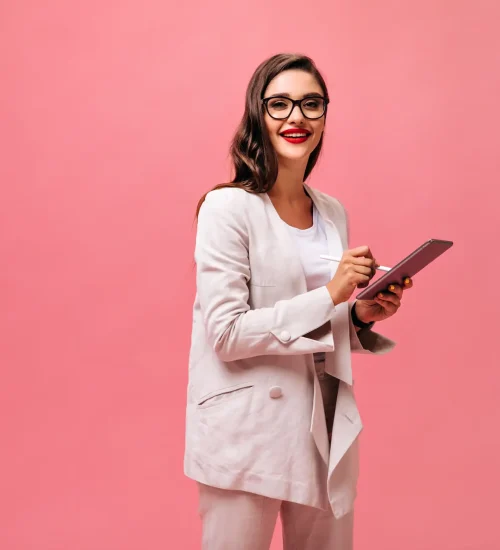 mujer-bonita-maravillosa-con-labios-rojos-en-chaqueta-de-moda-y-anteojos-posa-con-tableta-de-computadora-sobre-fondo-rosa-aislado